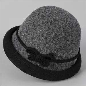 Détail d'un chapeau cloche en laine avec bord roulé contrasté et nœud noir élégant