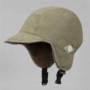 Close-up of khaki quilted trapper hat with warm brown sherpa fleece lining and buckle strap