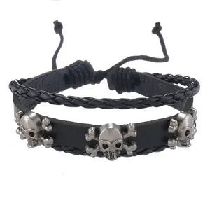 Detailansicht eines schwarzen Mehrschicht-Lederarmbandes mit silbernen Totenköpfen und Kordel