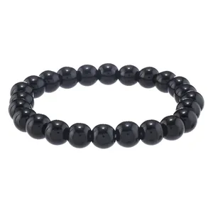 Dettaglio di perle di onice nera lucida su un braccialetto elastico dallo stile minimal