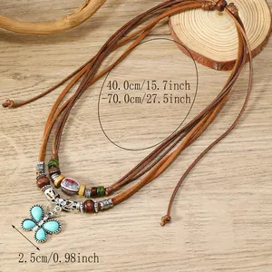 Detalle de un colgante de mariposa bohemio con piedras turquesas en un collar de cordón