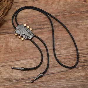 Detail of vintage bolo tie with guitar head pendant and Country Music engraving