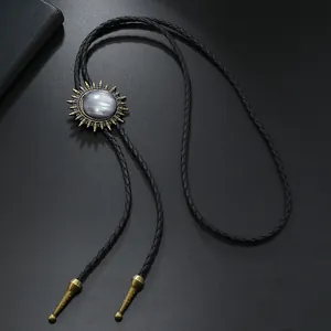 Détail d'une cravate bolo vintage avec pendentif soleil et pierre grise sur cordon