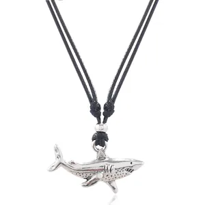 Macro view of vintage silver shark tooth pendant on black braided cord necklace