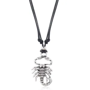 Detailed view of the antique silver scorpion pendant on a black woven cord necklace