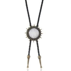 Détail de cravate bolo vintage avec médaillon soleil et pierre blanche irisée