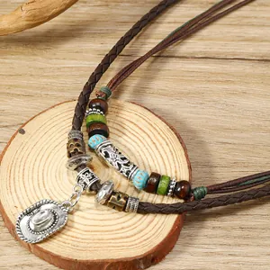 Detalle de collar bohemio de capas con cuentas de madera y colgante de sombrero cowboy
