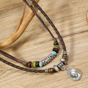 Primer plano de un collar bohemio de varias capas con un colgante de sombrero de vaquero