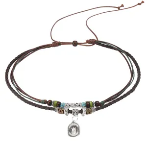 Detalle de collar bohemio multicapa con colgante de sombrero vaquero y cuentas