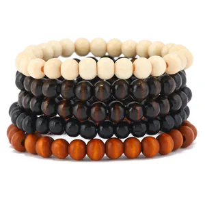 Detail von gestapelten Boho-Holzperlenarmbändern in Creme-, Braun- und Schwarztönen