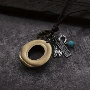 Close-up of western cowboy hat pendant with horsehead, horseshoe and turquoise on leather cord