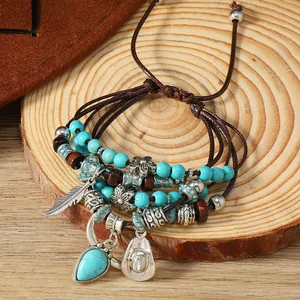 Boho πολύστρωτο βραχιόλι με τιρκουάζ χάντρες και γούρια σε ξύλινη επιφάνεια