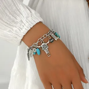 Detail of bohemian silver chain bracelet with turquoise beads and western charm pendants