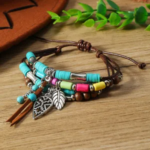 Λεπτομέρεια από boho πολύστρωτο βραχιόλι με χρωματιστές χάντρες και καφέ σουέτ φούντες
