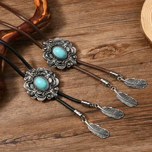 Nahaufnahme von Western Bolo-Krawatten mit Türkis-Inlay und silbernen Blattanhängern