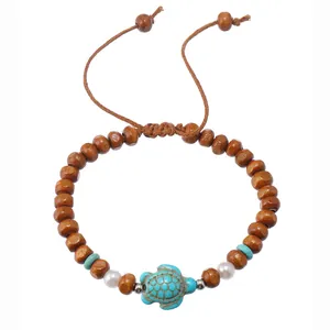 Close-up of beaded bracelet with brown wood beads, turquoise accents and a turtle charm