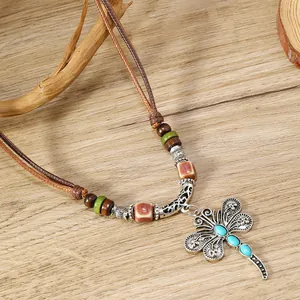 Primer plano de collar bohemio de libélula con piedras azules y cuentas de madera