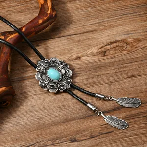 Detail von Vintage-Bolo-Krawatte mit Türkisstein und Metallfeder-Anhängern