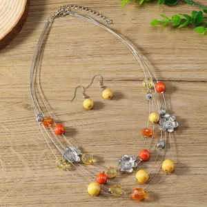 Detail of colorful multi-layer floral necklace and earring set on a wooden background