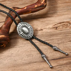 Vintage silver sunflower bolo tie with black braided leather cord on wooden background