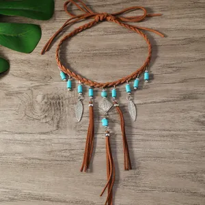 Détail du collier bohème avec perles turquoise et longs glands sur bois naturel