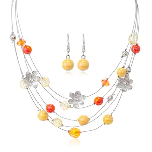 Detail of colorful beads and silver hollow flower charms on a multi-layer wire necklace set