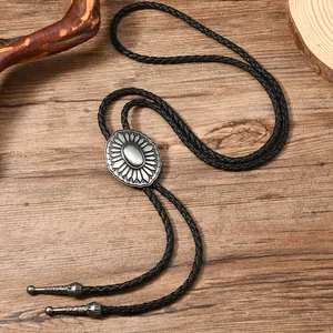 Detail of vintage bolo tie showing braided leather cord and silver floral metal slide