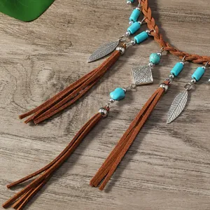 Détail du collier bohème avec perles turquoise et pendentifs en forme de plume