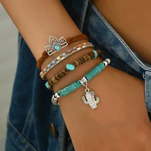 Primer plano de pulseras bohemias con cuentas de turquesa y detalle de dije de cactus