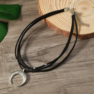 Gros plan du collier choker noir à trois couches avec pendentif lune et gravures ethniques