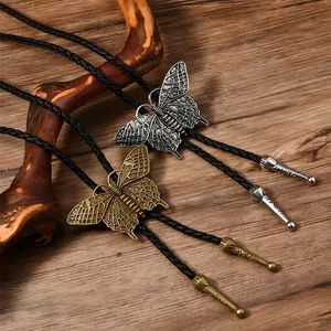 Detail von Vintage-Schmetterlings-Bolos mit strukturierten Flügeln an Lederkordeln