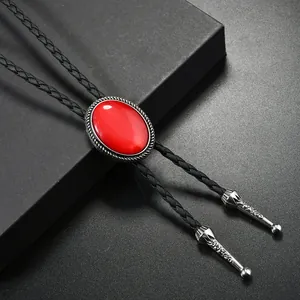 Détail du bolo tie avec pierre rouge, base argentée et cordon en cuir tressé noir