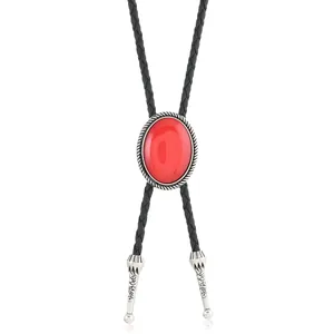 Détail d'une cravate bolo avec pierre rouge ovale et embouts en argent gravés