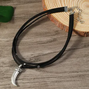 Détail d'un choker bohème avec pendentif corne argentée et cordons en velours noir tressés