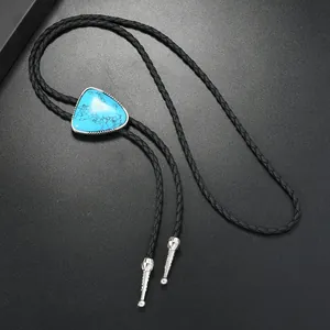 Macro view of triangular turquoise bolo tie with braided leather cord and silver aglets
