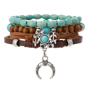 Detalle de pulsera multicapa bohemia con cuentas turquesas, cuero y colgante de cuerno