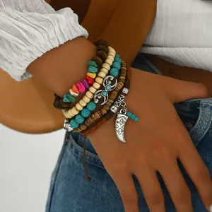 Detalle de pulseras bohemias de capas con cuentas de turquesa y colgante de cuerno vintage