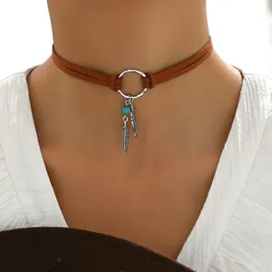 Détail du choker bohème avec perles turquoise, plumes en métal et cordon en suédine marron