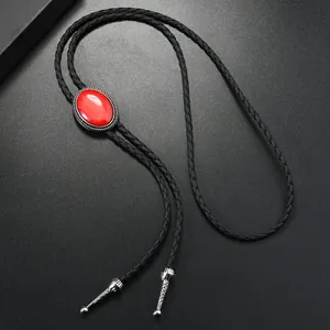 Détail de bolo tie avec pierre rouge, cadre argenté rétro et cordon en cuir tressé noir