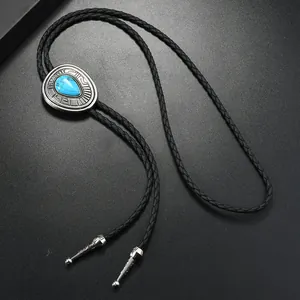 Detail of western bolo tie with engraved metal pendant and teardrop turquoise stone