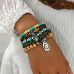 Primer plano de pulseras bohemias multicapa con cuentas de turquesa y dijes de madera