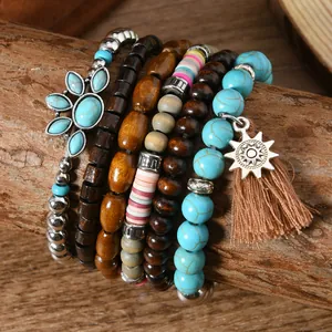 Detail von Boho-Armbändern mit Sonnenanhänger und Holzperlen auf einem rustikalen Ast
