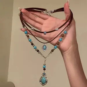 Detail of bohemian layered necklace featuring turquoise beads and western charms