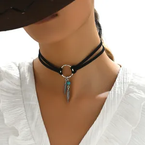 Détail d'un choker bohème noir avec pendentifs plumes argentées et perle turquoise