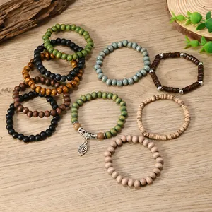 Detail of bohemian layered bead bracelets with coconut shell wood and a metal leaf charm