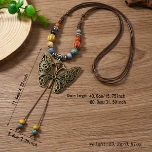 Detail showing oversized bronze butterfly pendant with colorful beads on wax cord