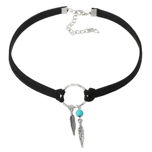 Détail d'un ras-du-cou bohème noir avec pendentifs plumes argentées et perle bleue