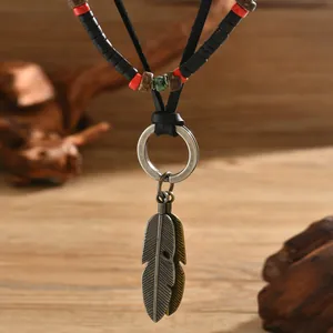 Mens bohemian leather necklace set with wood beads and metal feathers on wood background