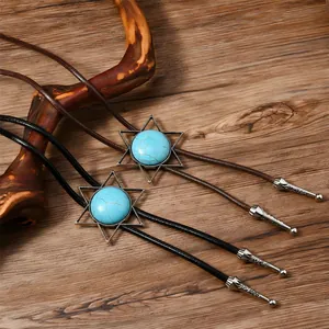 Detail der Western-Bolo-Krawatte mit Türkis-Inlay und gravierten Metallspitzen