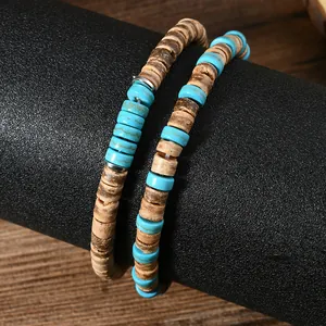 Primo piano di perline turchesi e ciondoli in cocco su un set di bracciali a strati